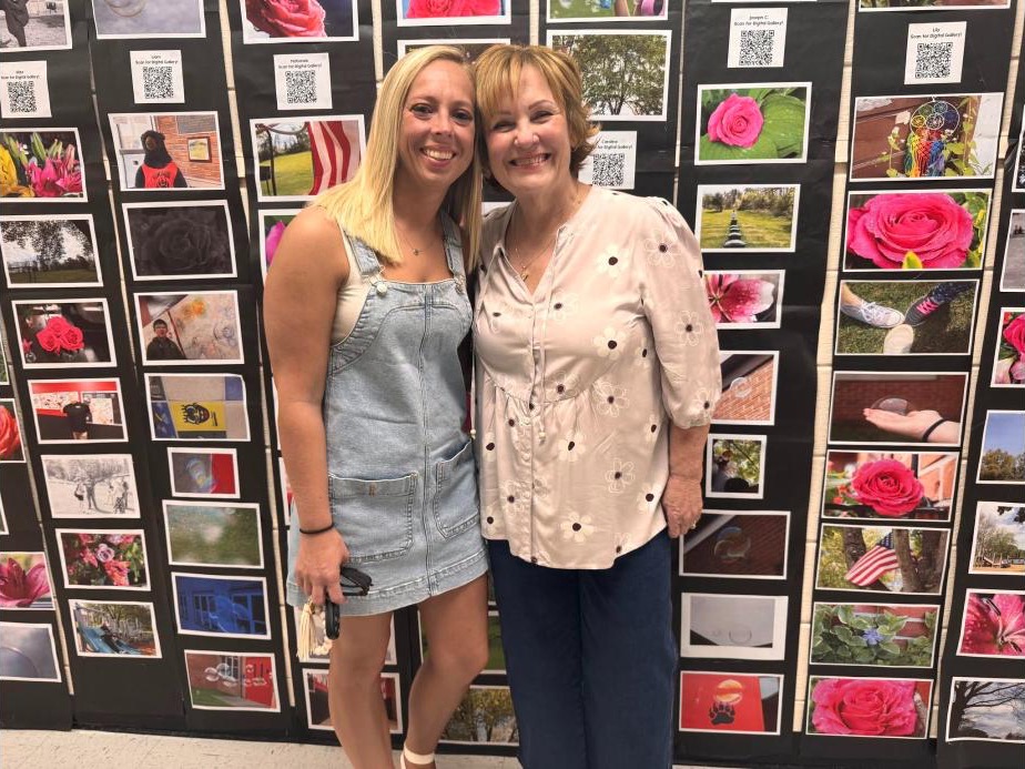 Jaime Johnson, left, and Andree Campbell, right, standing in front of a student photography display